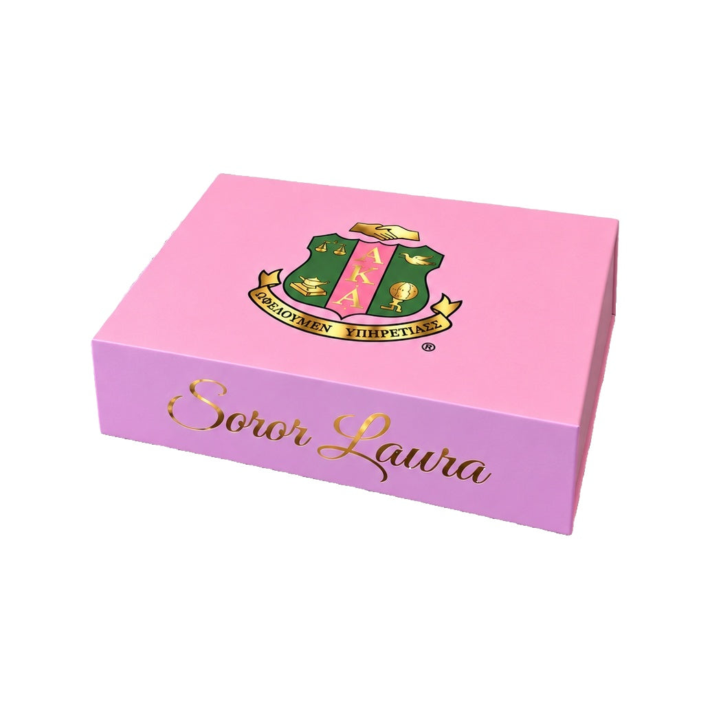Single pink AKA collectible gift box personalized with Soror Laura and the AKA shield, shown from the front and above.
