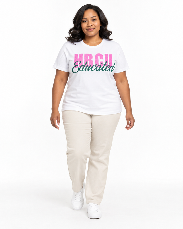 Model in a relaxed walking pose wearing a white short-sleeve HBCU Educated Tee with pink glitter lettering and matte green script.
